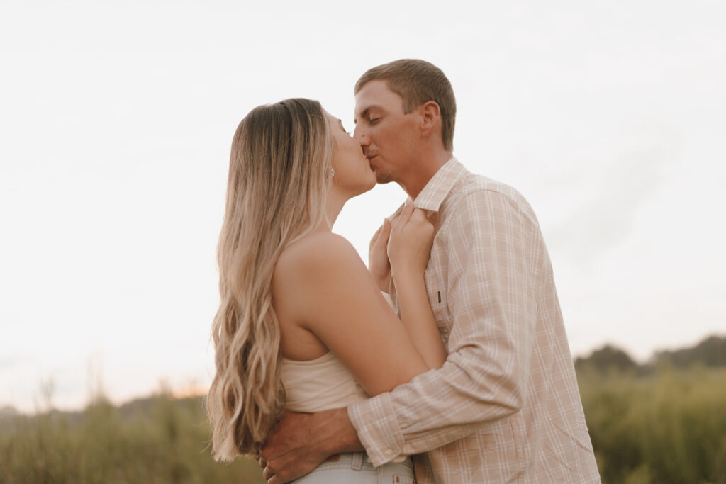 couple kissing pose in field