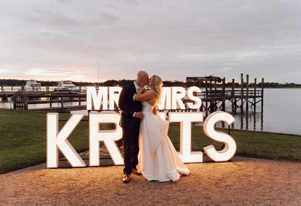 charleston wedding photographer bride and groom kissing in front of name sign