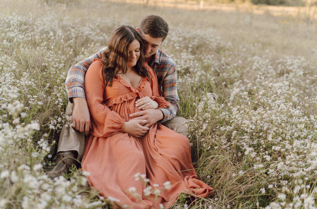 couple posing in field with wildflowers