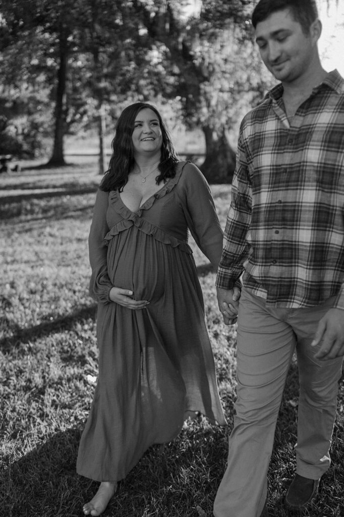 couple holding hands and walking candid maternity photos