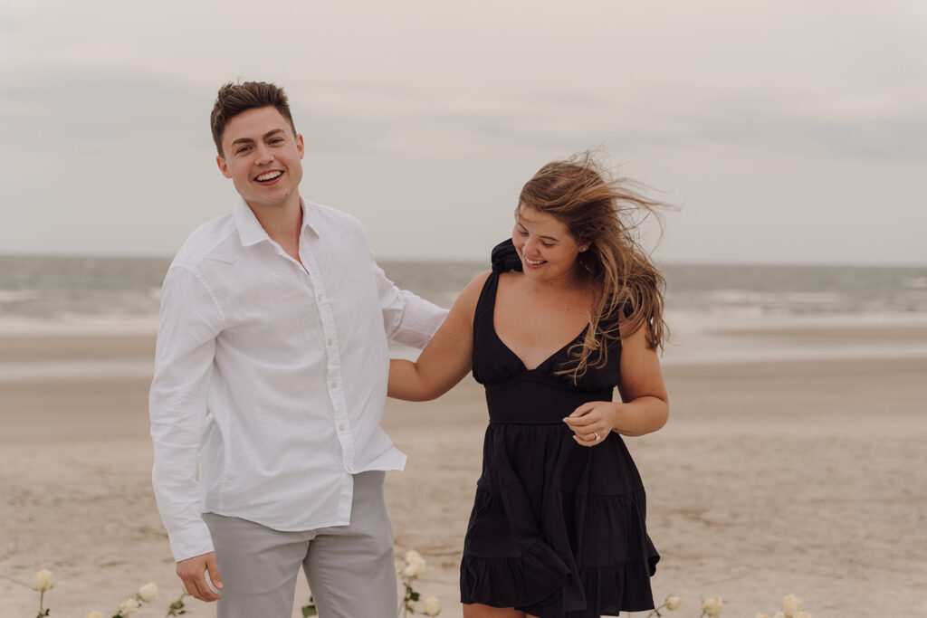 couple smiling and laughing during proposal on the beach