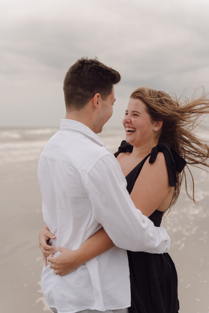 couple smiling and hugging on the beach