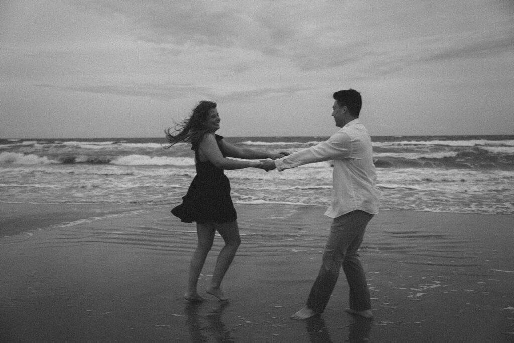 couple smiling and spinning on the beach in south carolina