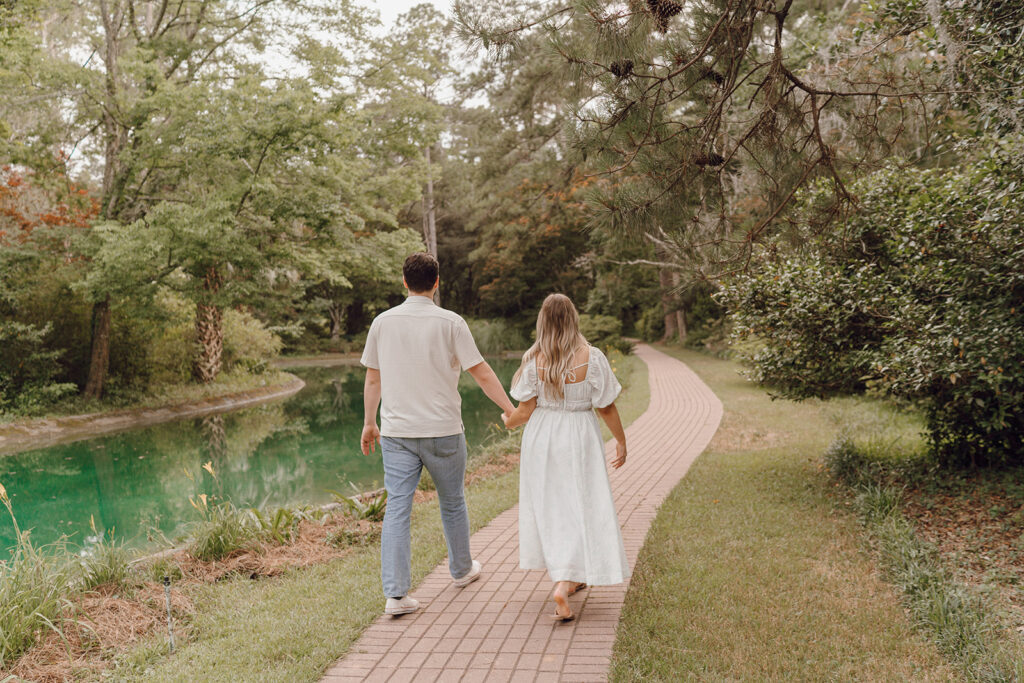 couple holding hands and walking in maclay gardens state park tallahassee