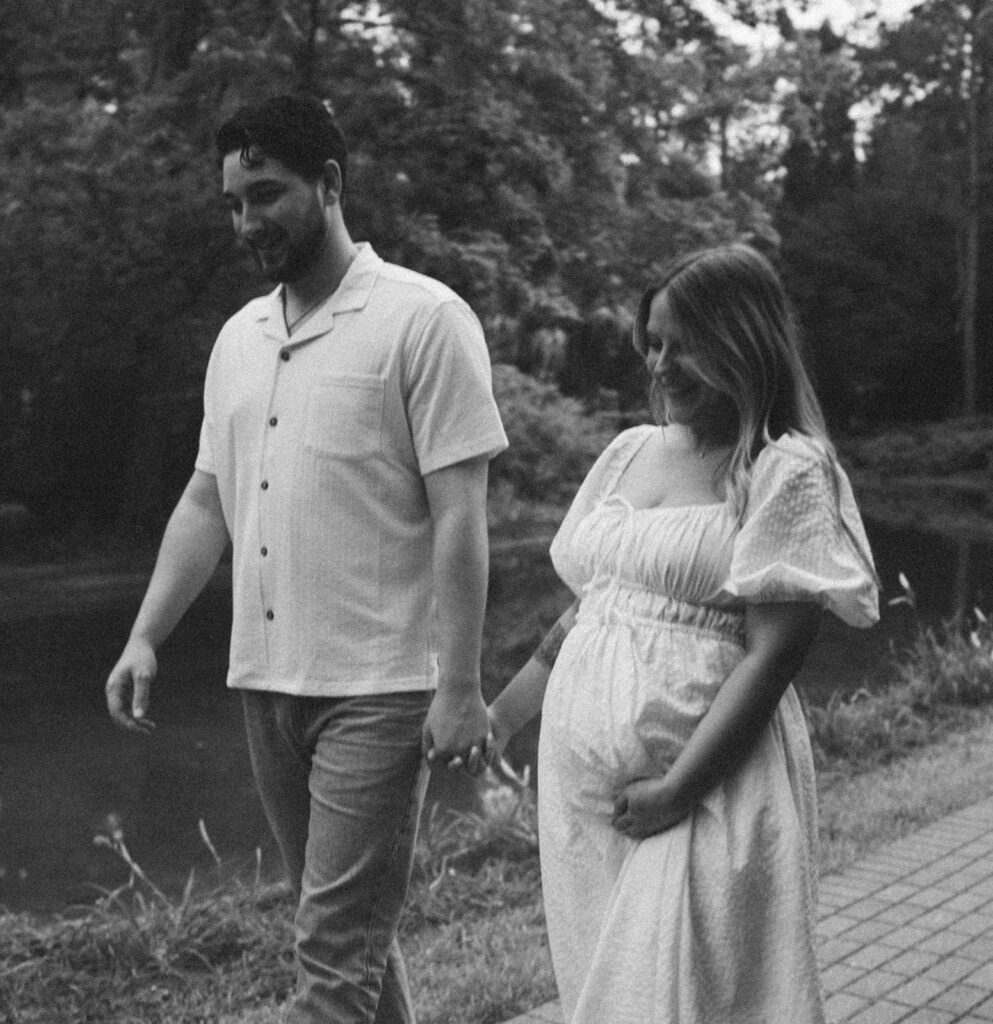 couple holding hands and walking on pathway in park