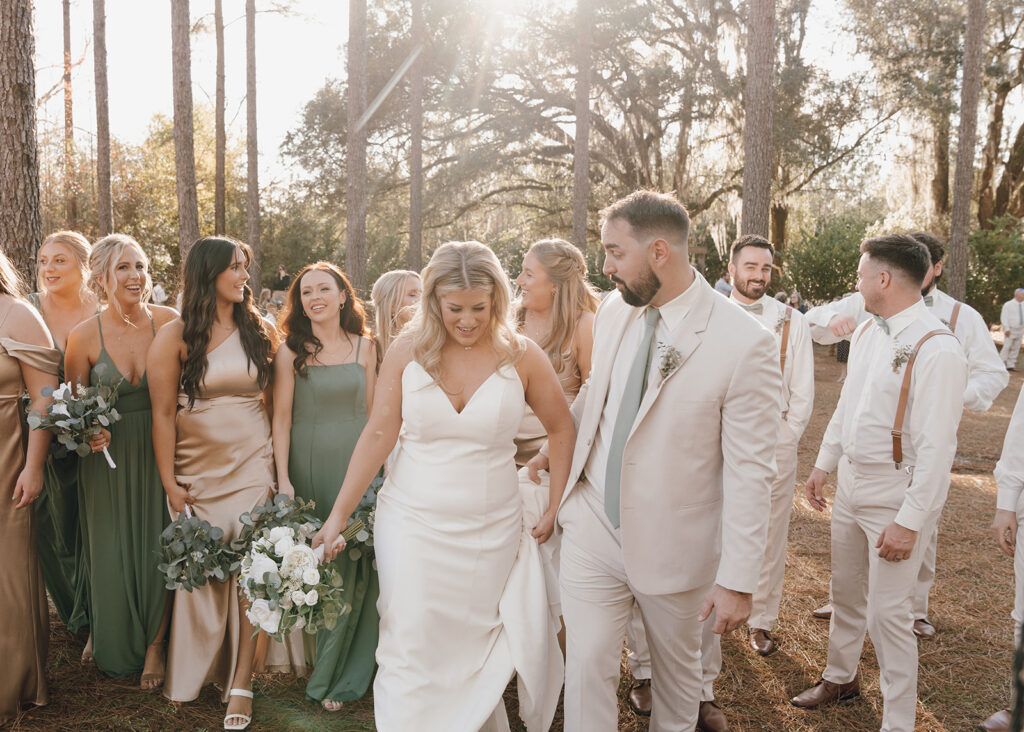 bride and groom walking with bridal party candid wedding photos