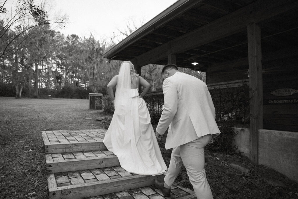 bride and groom walking up steps during golden hour the homestead barn