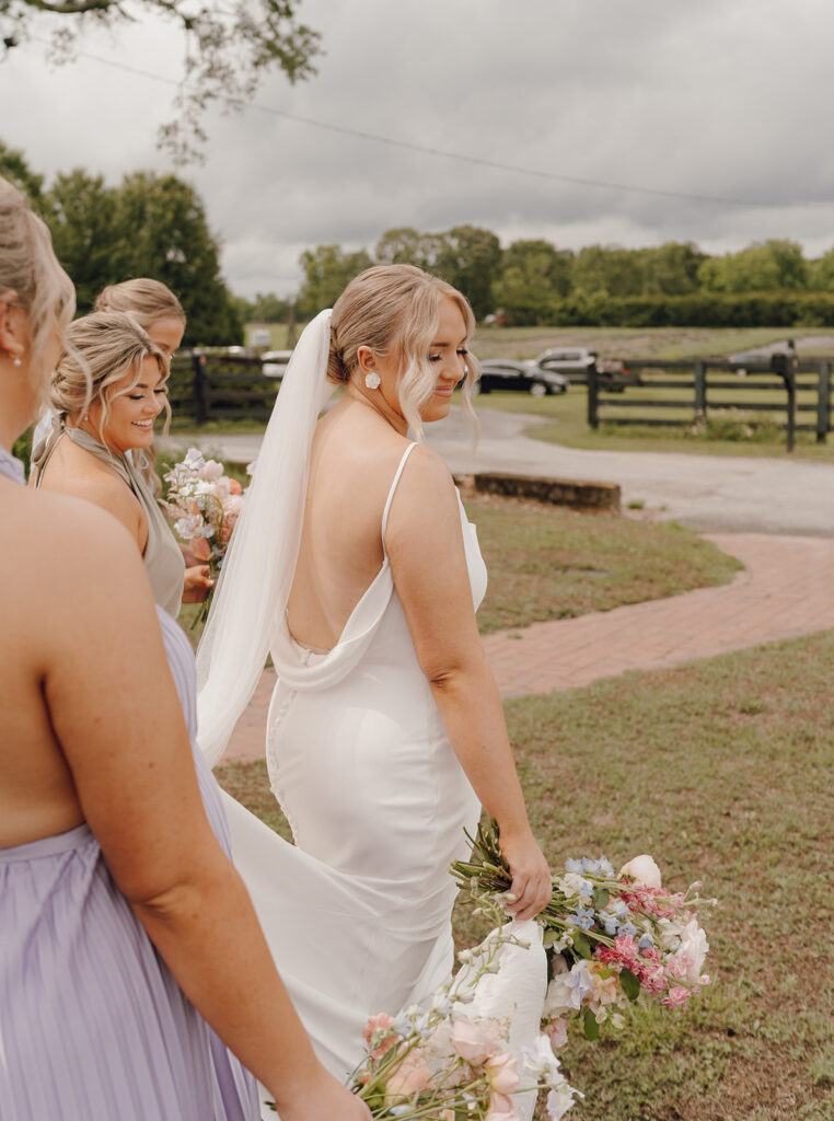 bride walking with bridal party holding spring bridal bouquet