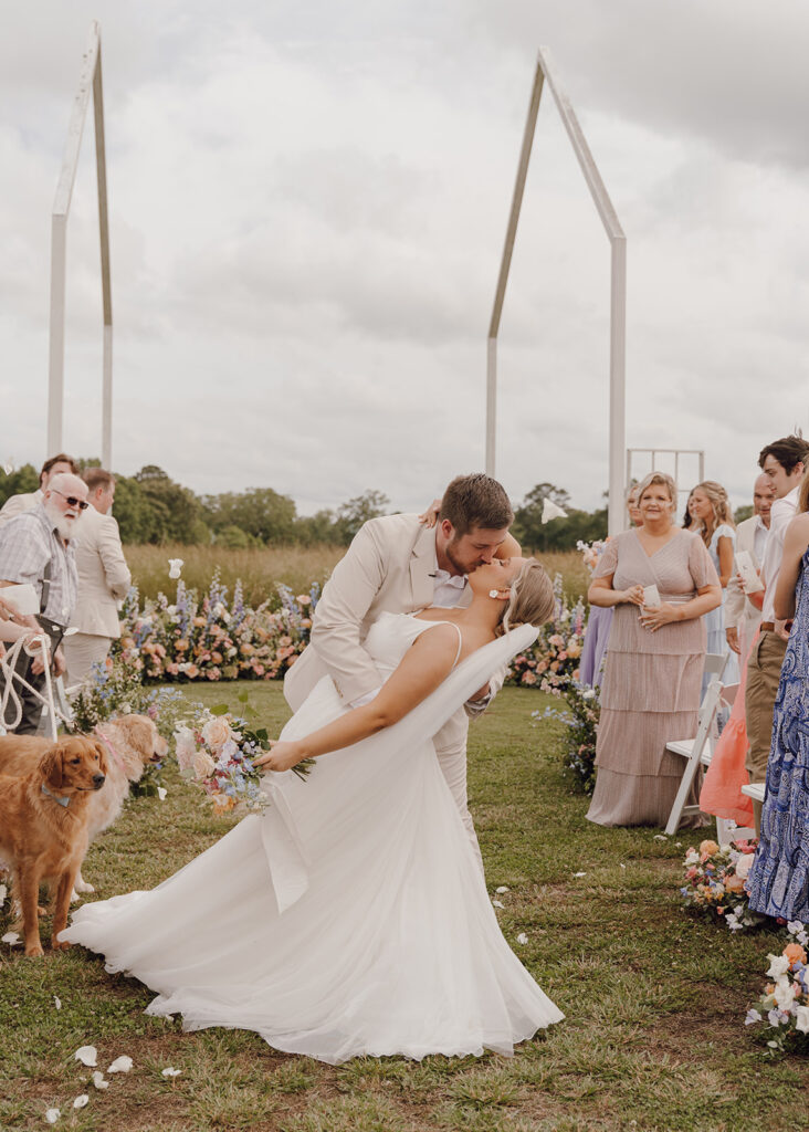 bride and groom kissing in aisle after ceremony