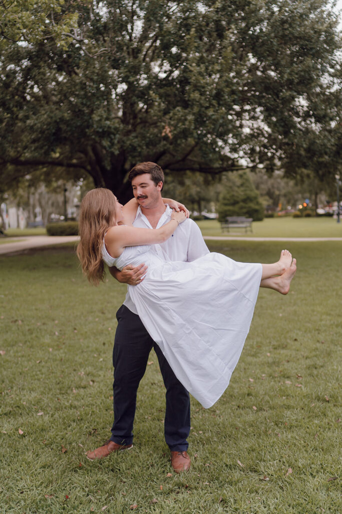 couple carry pose engagement photos in florida hannibal square