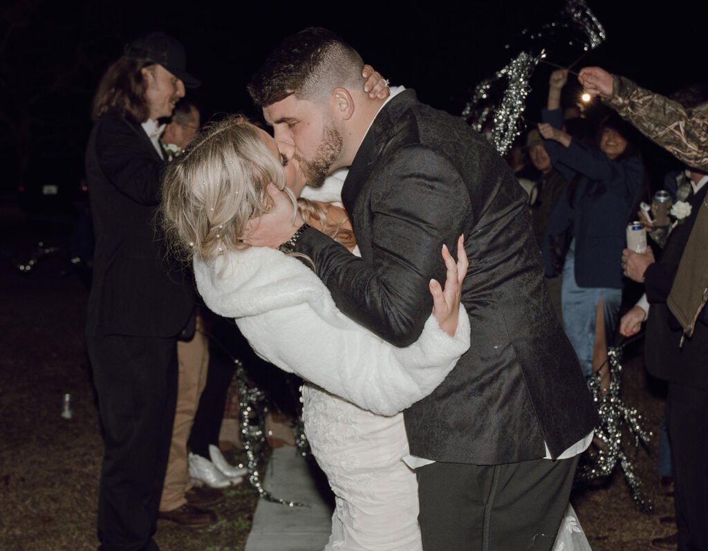 bride and groom kissing during wedding exit