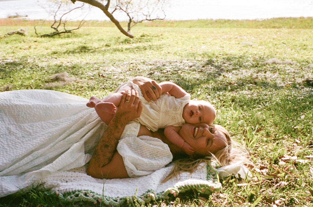 mom and baby smiling on a picnic blanket in Tallahassee