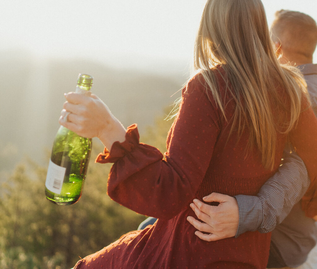 popping the Champagne engagement photos in the mountains