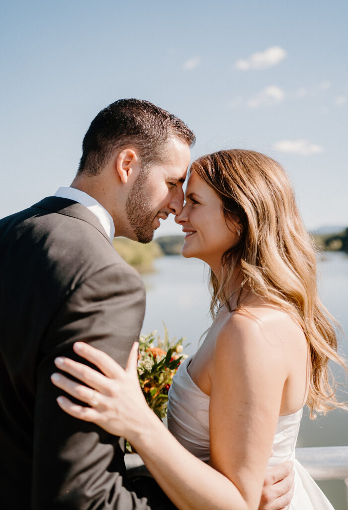 bride and groom smiling for wedding portraits during golden hour