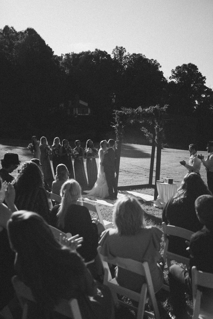 bride and groom first kiss as husband and wife at the fields of blackberry cove