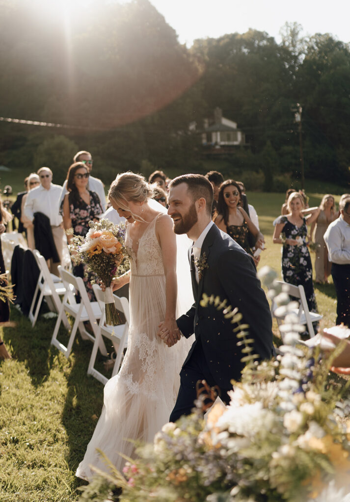 bride and groom walking back down the aisle after ceremony at the fields of blackberry cove