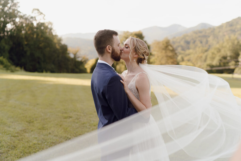 romantic bride and groom wedding photos in front of the mountains at the fields of blackberry cove