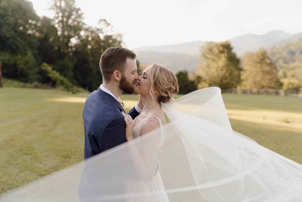 romantic bride and groom wedding photos in front of the mountains at the fields of blackberry cove