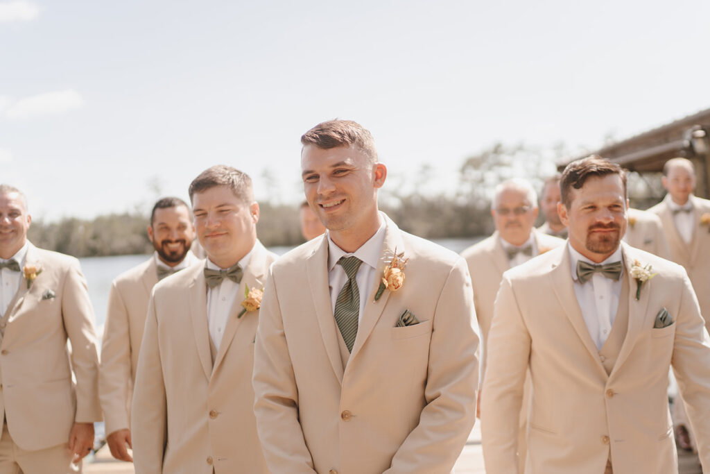 groom smiling with groomsmen candid wedding photos