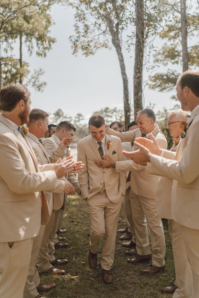 groom smiling with groomsmen candid wedding photos