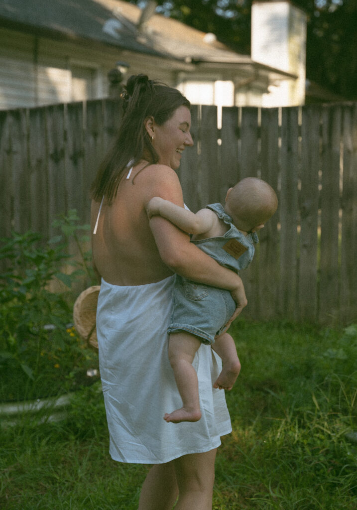 mom and baby playing on picnic blanket in backyard