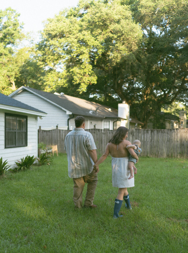 couple holding hands and walking in their backyard