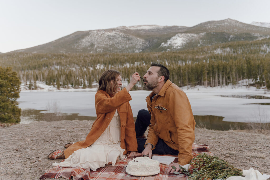 colorado destination wedding photos bride and groom eating cake