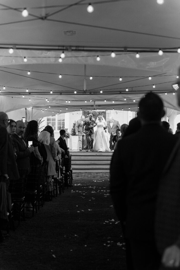 cozy winter wedding ceremony with twinkling lights and Christmas trees