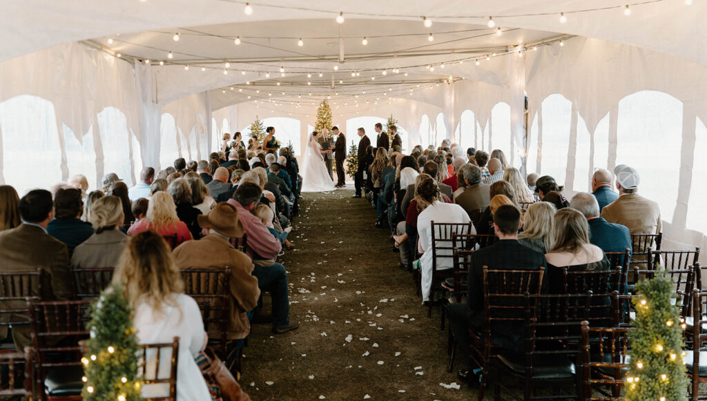 cozy winter wedding ceremony with twinkling lights and Christmas trees