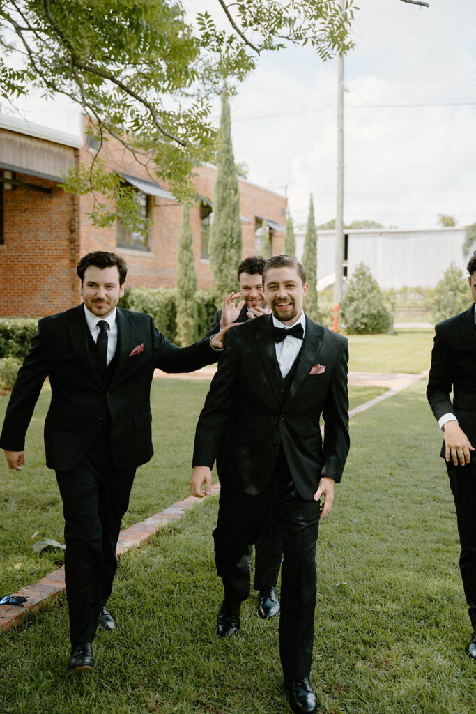groomsmen walking candid wedding photos with bridal party