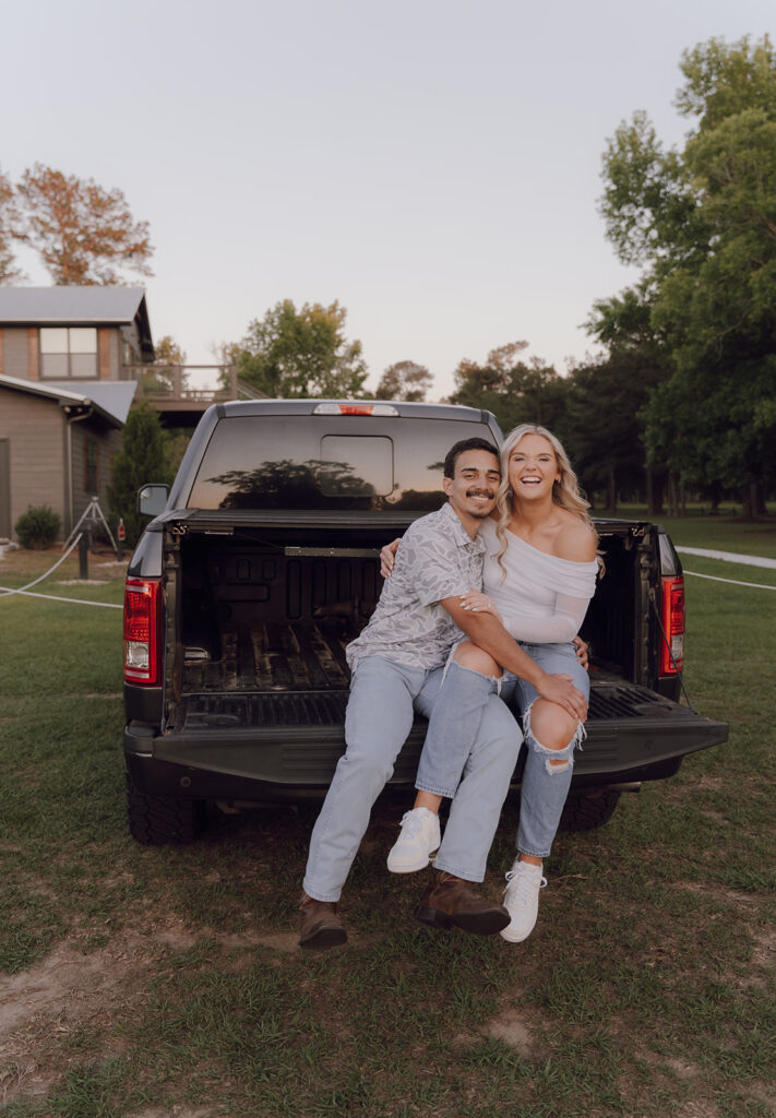 couple smiling sitting on the truck bed