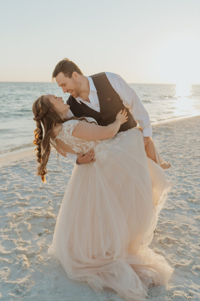 Groom holding his bride as he looks into her eyes.