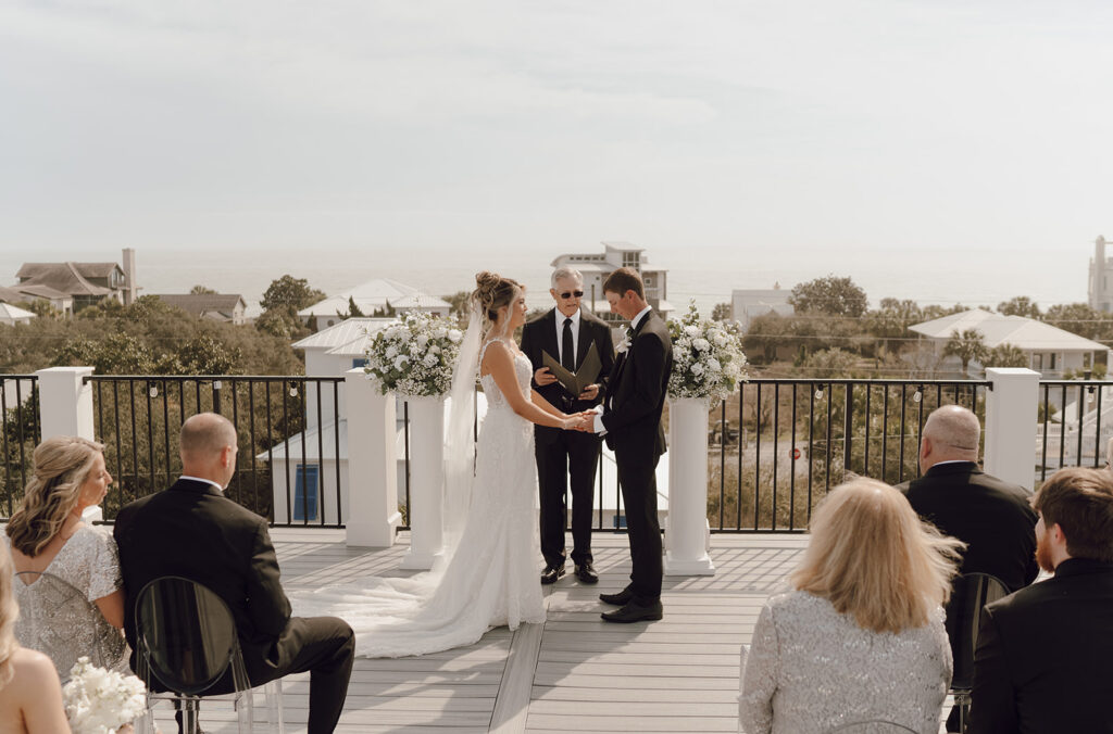 Bride and groom holding hands during their 30A beach wedding ceremony.