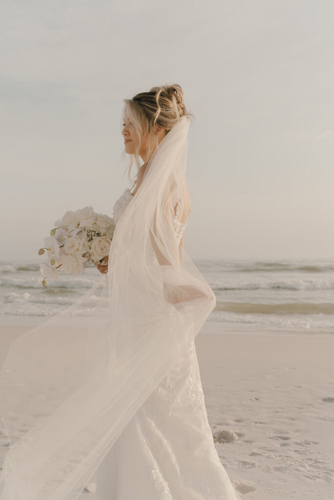 Bride holding her veil in the wind.