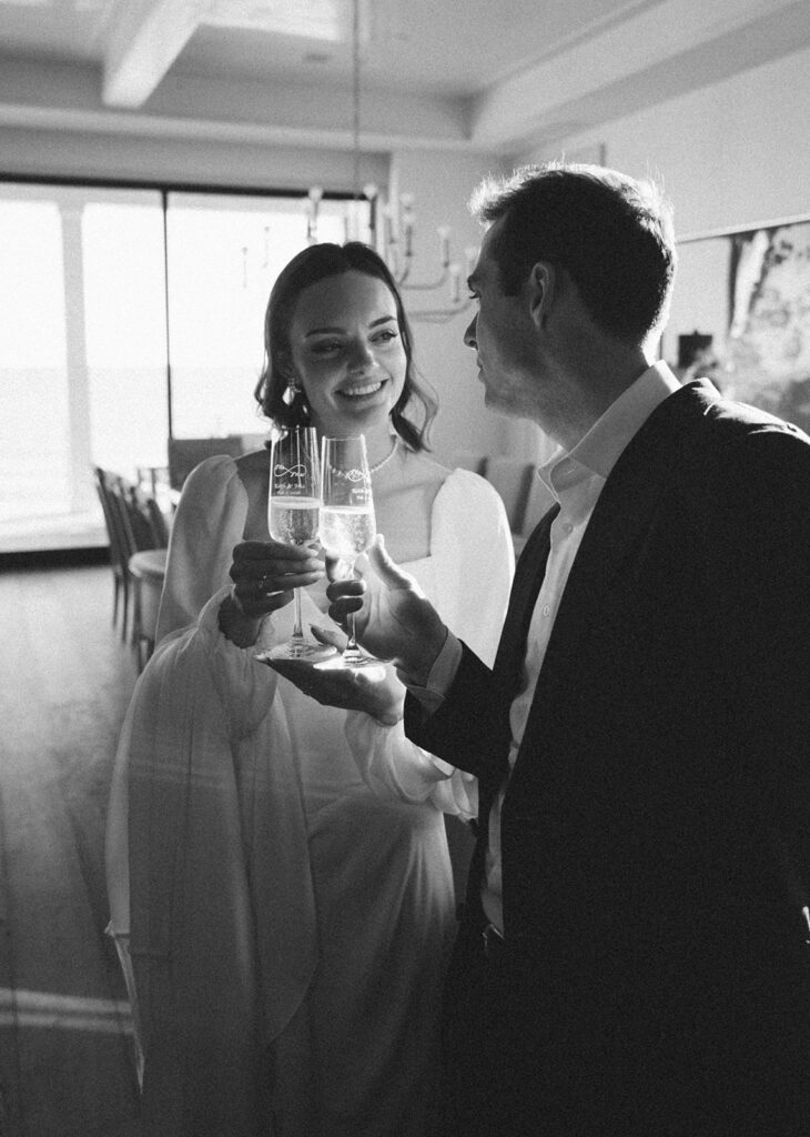 Bride and groom smiling and drinking champagne. 