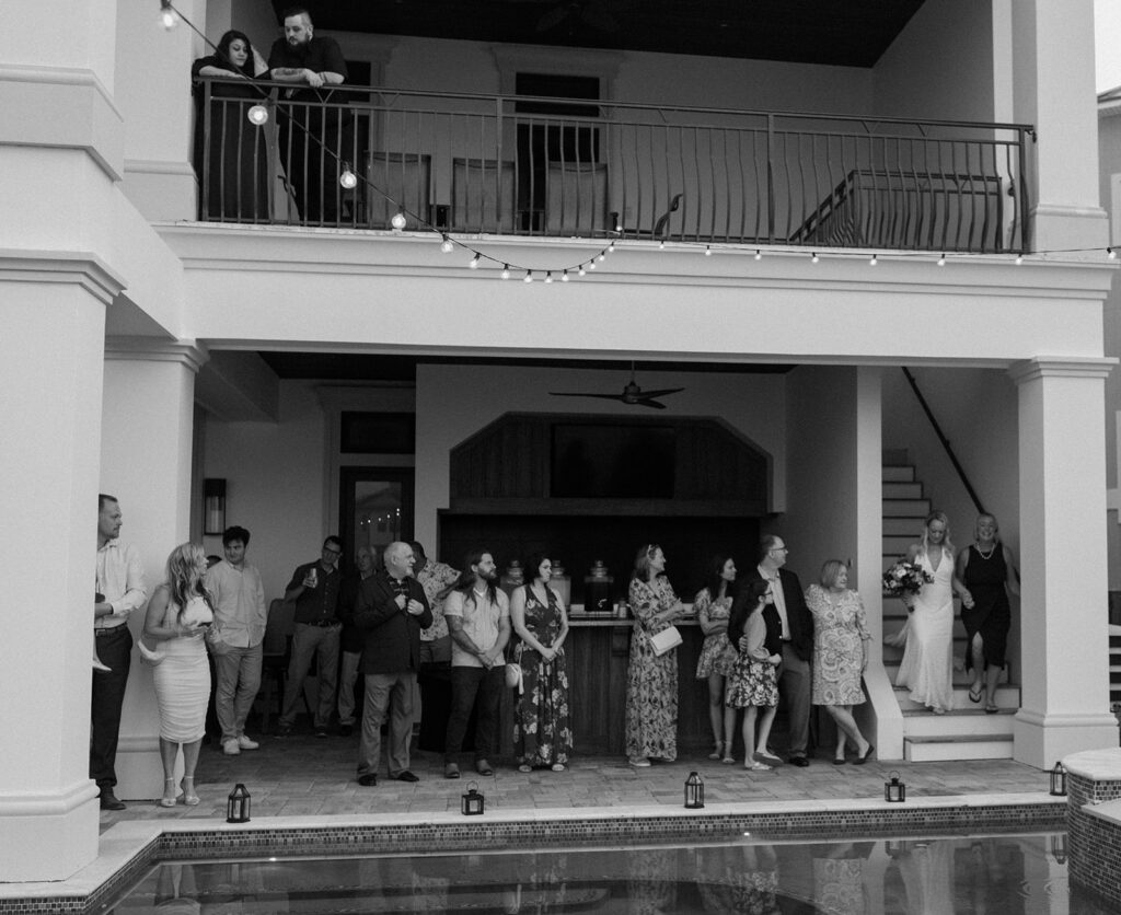 Wedding guests waiting for the Bahamas wedding ceremony by a pool.