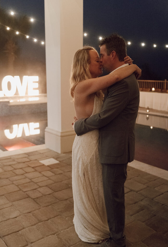 Bride and groom having their first dance by the pool.