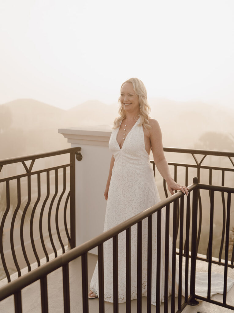 A bride smiling on the rooftop of her Bahamas destination wedding.