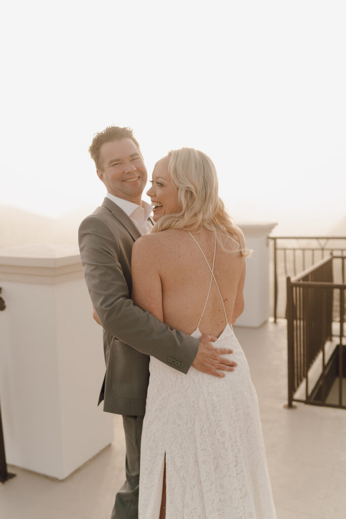 Bride and groom smiling and laughing as they hug before their Bahamas beach wedding.