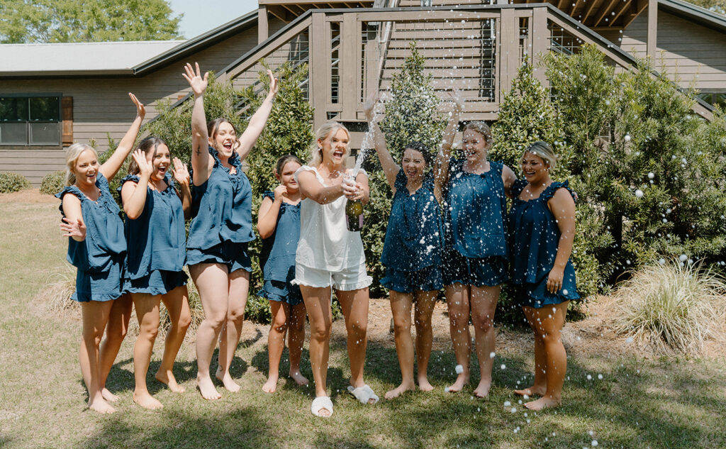 Bridal party spraying champagne for candid wedding photos. 