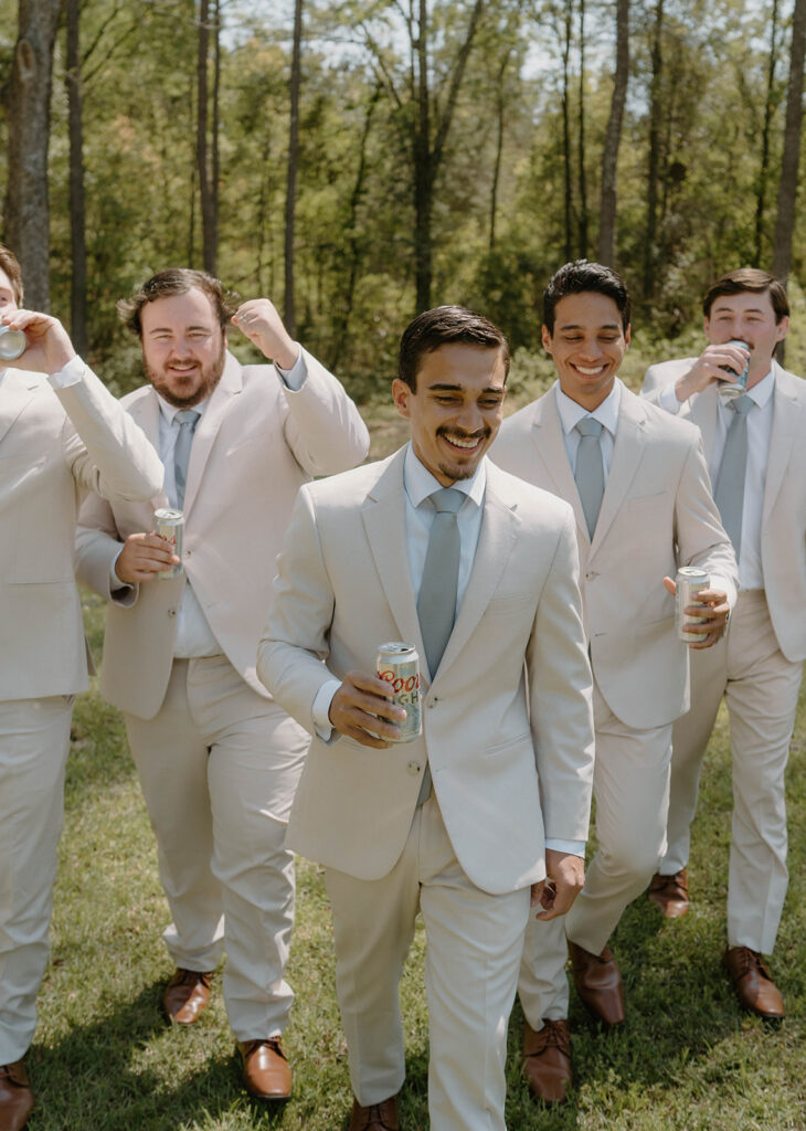 Groomsmen walking with beer in their hands.