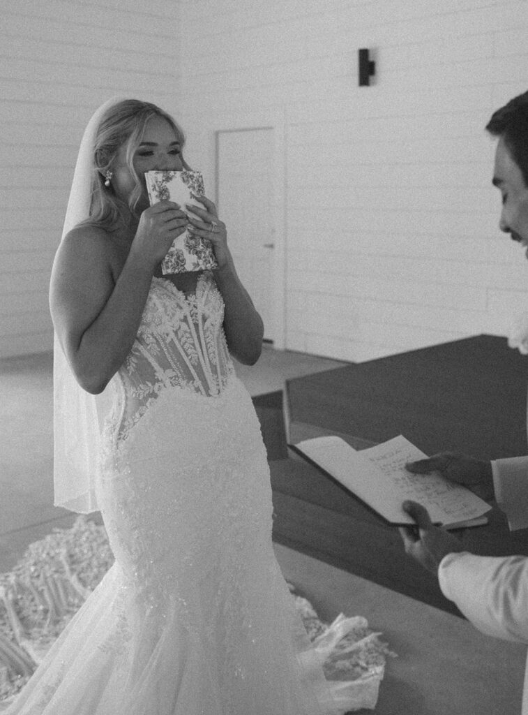 Candid wedding photos of the bride laughing as she hears the groom's vows. 