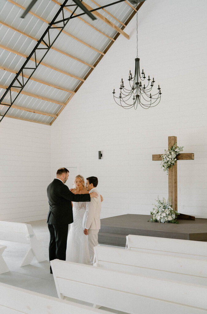 A pastor praying of the bride and groom before the wedding ceremony.