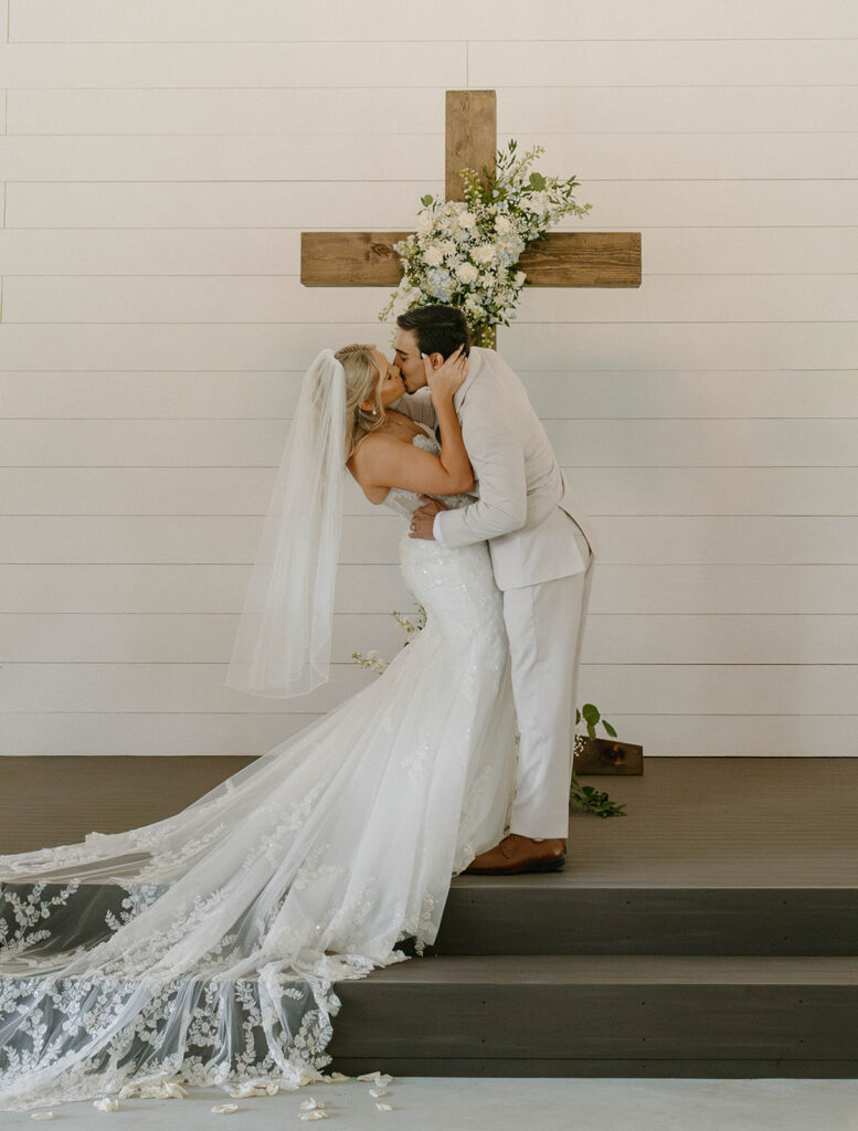 Bride and groom kissing by a cross at the chapel at Mount Pleasant Lodge in North Florida.