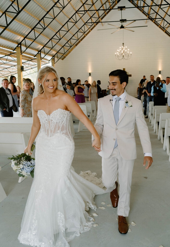 Candid wedding photos of the bride and groom exiting the ceremony happily. 