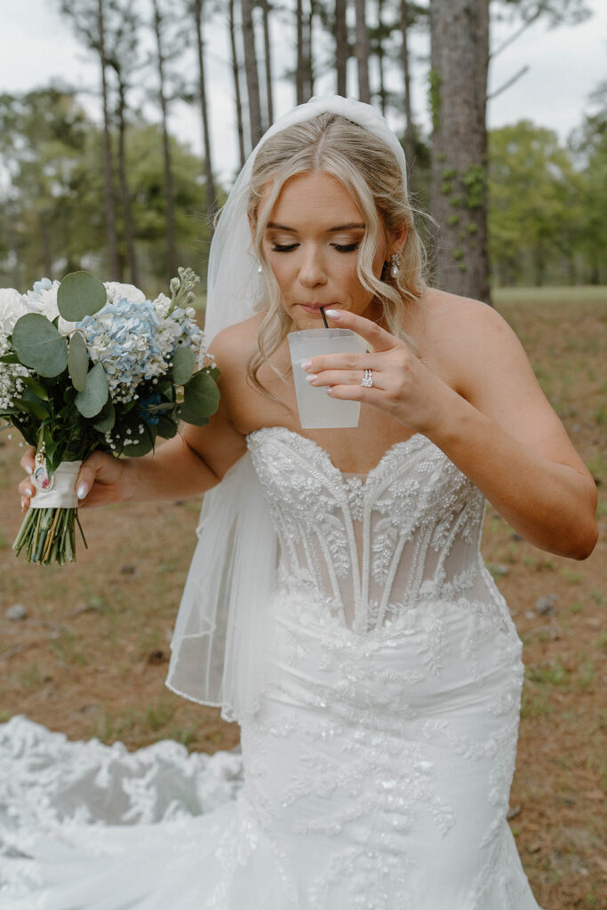 Candid wedding photos of bride drinking during photos.