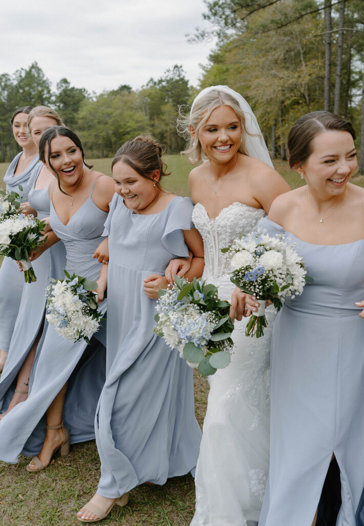 Bride walking and smiling with her bridesmaids.