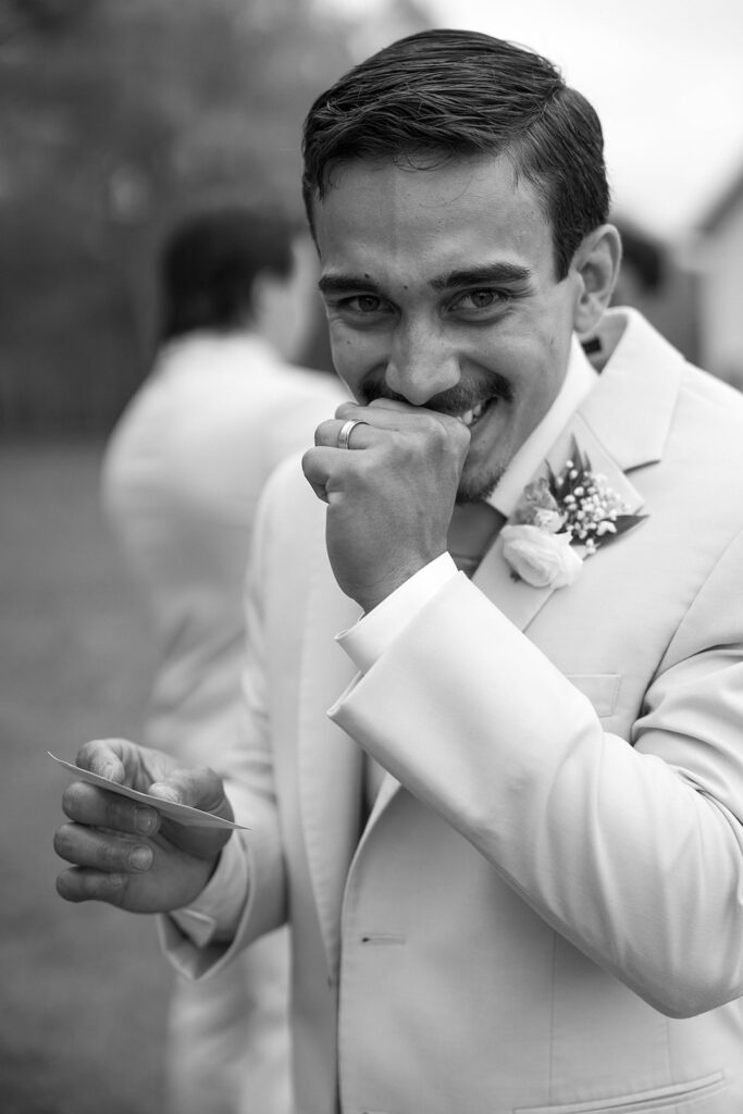 Groom giggling over something funny during candid wedding photos. 