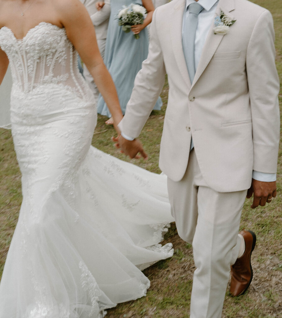 Bride and groom holding hands.