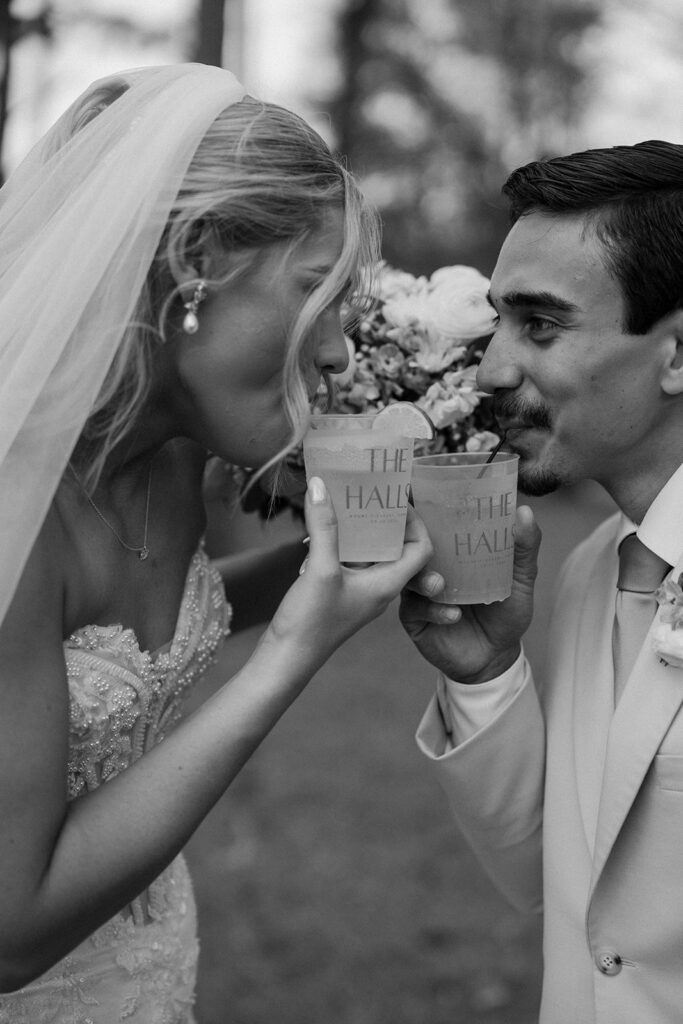 Bride and groom candidly drinking a cocktail. 